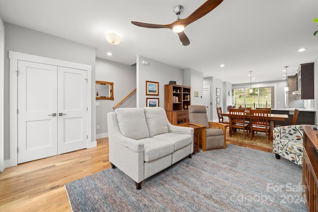 living room with light wood-type flooring and ceiling fan