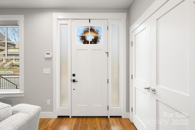 entrance foyer with baseboards and light wood finished floors