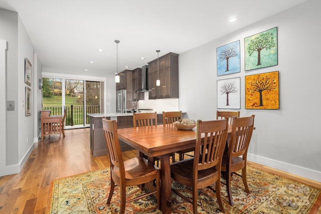 dining space with baseboards, recessed lighting, and light wood finished floors