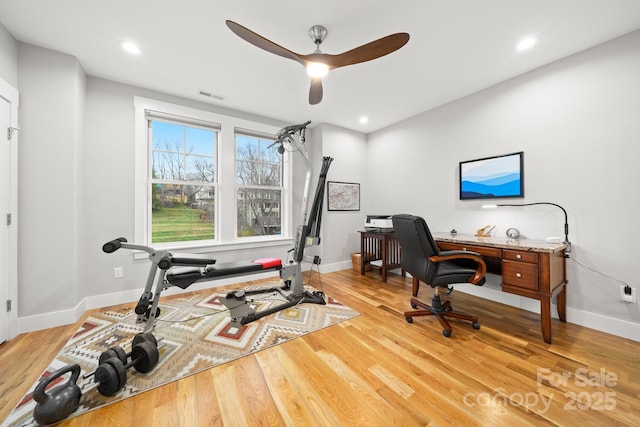 home office featuring baseboards, a ceiling fan, light wood-type flooring, and visible vents