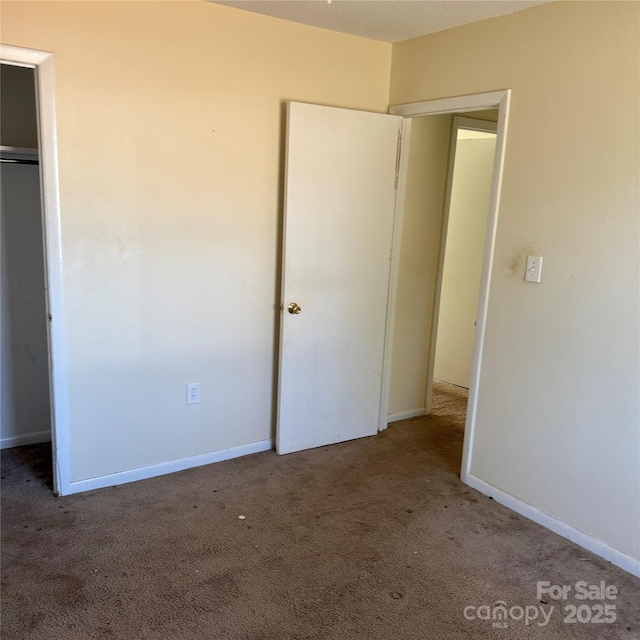 unfurnished bedroom with carpet floors, a closet, and baseboards