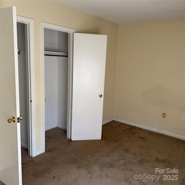 unfurnished bedroom with carpet floors, a closet, and baseboards