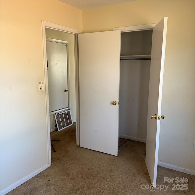 unfurnished bedroom featuring light carpet, a closet, visible vents, and baseboards