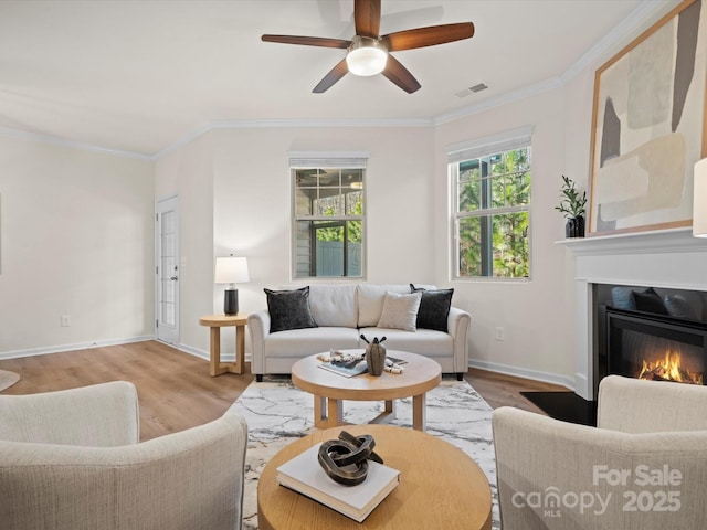 living room featuring ceiling fan, light hardwood / wood-style floors, and ornamental molding