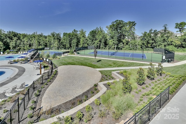 surrounding community featuring a yard and tennis court