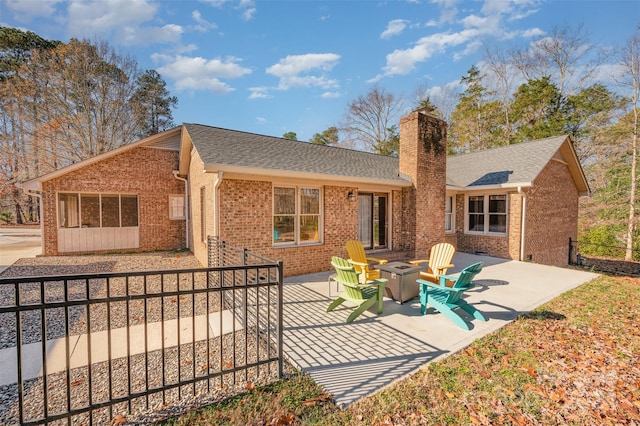 back of property featuring a patio and a fire pit