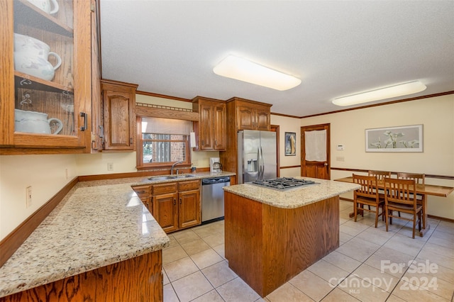 kitchen featuring sink, a center island, ornamental molding, and appliances with stainless steel finishes