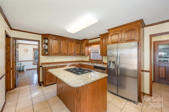 kitchen with light tile patterned floors, a kitchen island, stainless steel appliances, and a textured ceiling