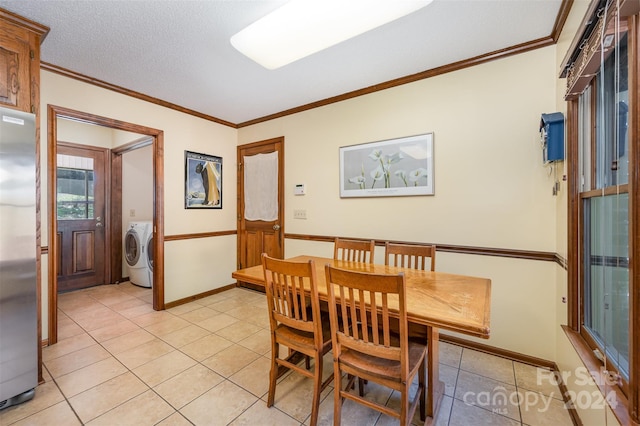 dining room with washer / dryer, a textured ceiling, light tile patterned floors, and ornamental molding