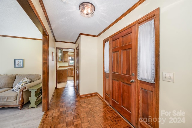 foyer featuring dark parquet floors, ornamental molding, and a textured ceiling