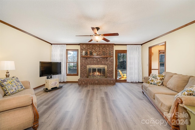 living room featuring wood-type flooring, a textured ceiling, a brick fireplace, and a wealth of natural light