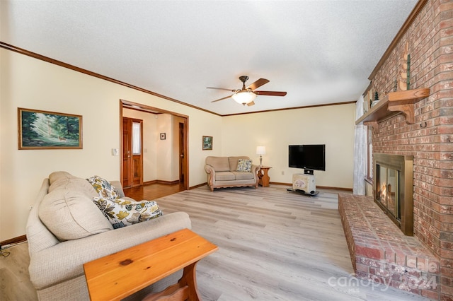 living room with ceiling fan, light hardwood / wood-style floors, crown molding, and a brick fireplace