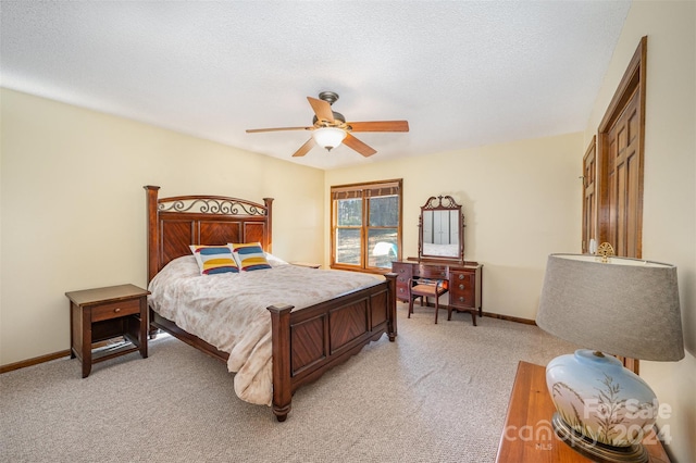 carpeted bedroom featuring ceiling fan and a textured ceiling