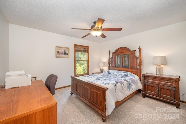 carpeted bedroom featuring ceiling fan and a textured ceiling