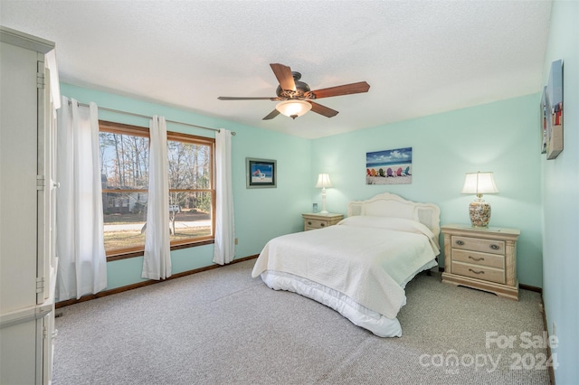 bedroom featuring light carpet, a textured ceiling, and ceiling fan