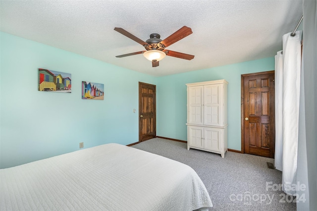 carpeted bedroom with ceiling fan and a textured ceiling