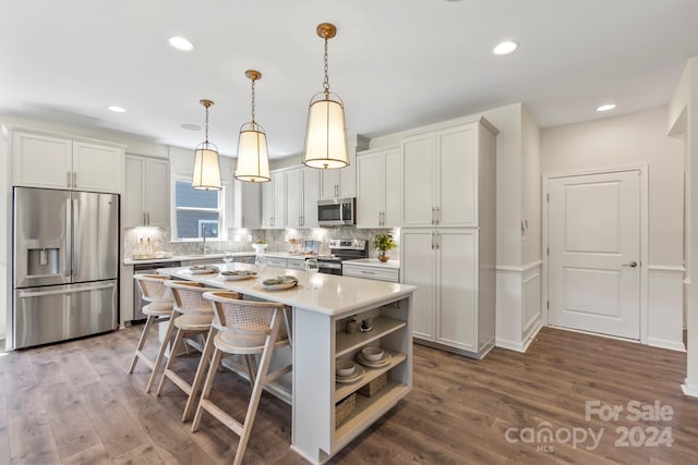 kitchen with pendant lighting, a center island, stainless steel appliances, and wood-type flooring