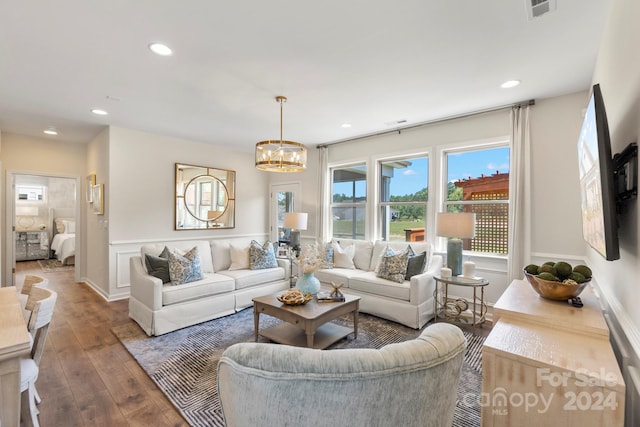 living room featuring dark hardwood / wood-style flooring and an inviting chandelier