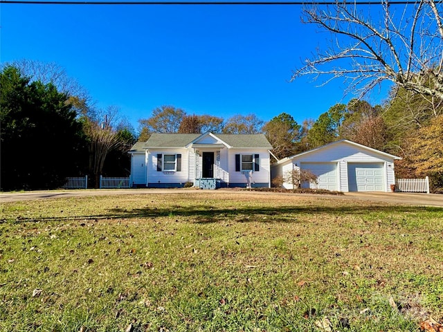 ranch-style home featuring a garage, an outbuilding, and a front lawn