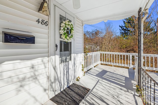 wooden deck featuring covered porch and ceiling fan