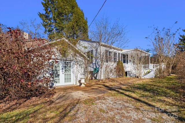 back of house with french doors and a yard