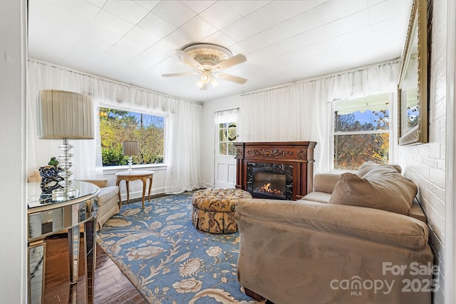 living room featuring ceiling fan and a fireplace