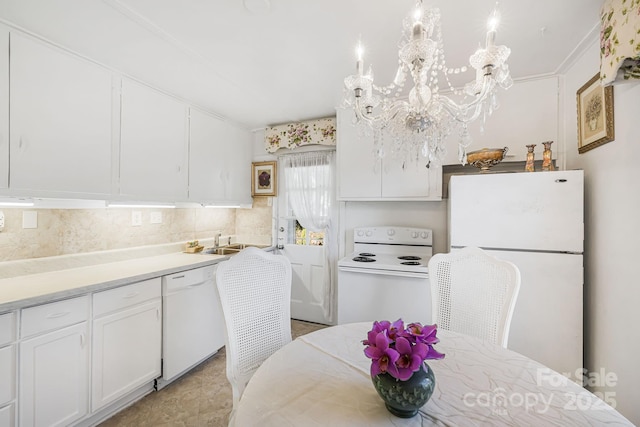 kitchen featuring sink, white appliances, white cabinets, and hanging light fixtures