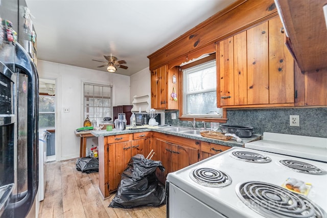 kitchen with backsplash, black fridge, electric stove, ceiling fan, and light hardwood / wood-style floors