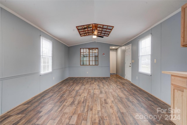 interior space with ceiling fan, dark hardwood / wood-style flooring, ornamental molding, and vaulted ceiling