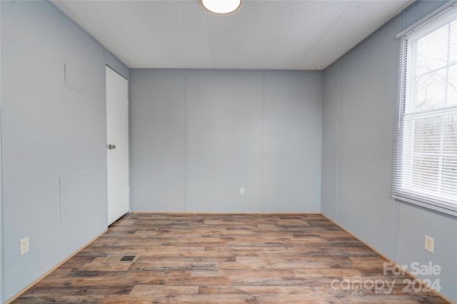 spare room featuring hardwood / wood-style flooring and a textured ceiling