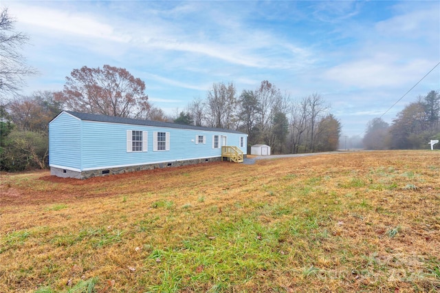 view of front of home with a front lawn and a storage shed