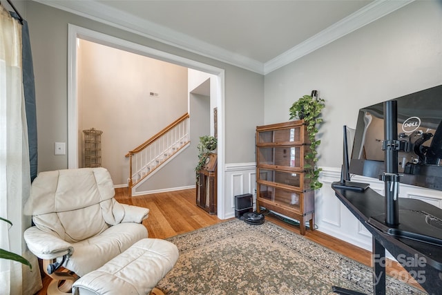 sitting room with wood-type flooring and ornamental molding