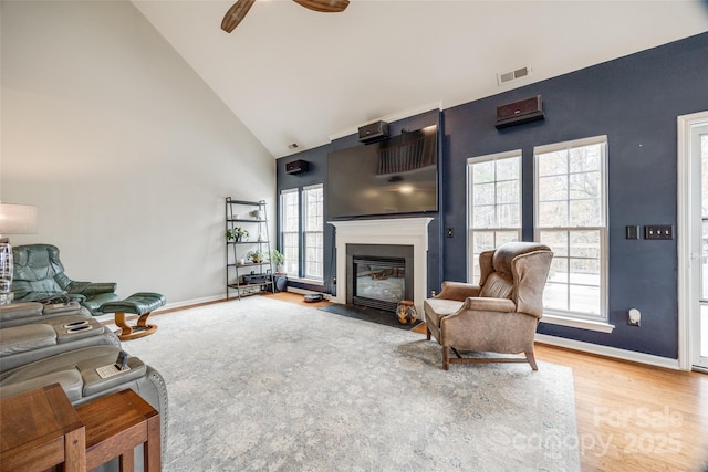 living room with light hardwood / wood-style floors, high vaulted ceiling, and ceiling fan