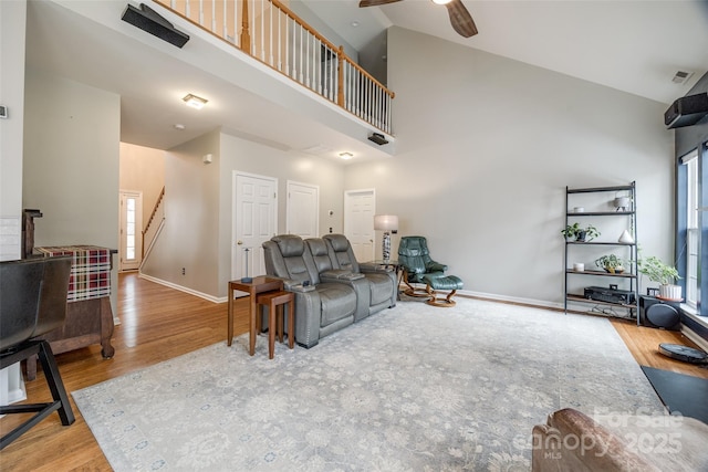 living room with ceiling fan, high vaulted ceiling, and hardwood / wood-style flooring