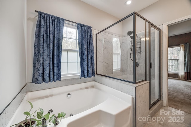 bathroom with a wealth of natural light and shower with separate bathtub