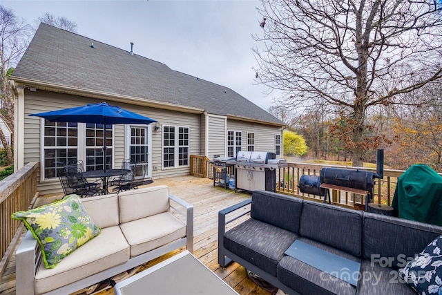 wooden terrace with an outdoor living space and grilling area