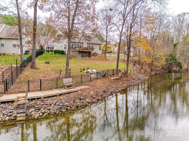 dock area with a deck with water view and a yard