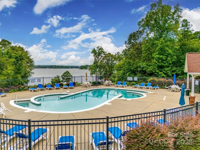 view of swimming pool featuring a patio area and a water view