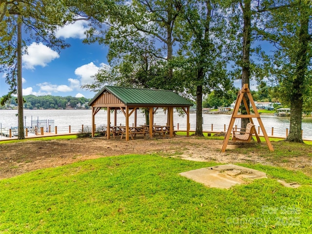 view of yard with a boat dock, a water view, and a gazebo