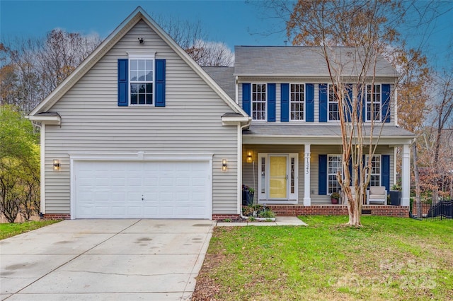 view of front of home featuring a garage, a front yard, and covered porch