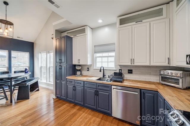 kitchen with white cabinetry, stainless steel dishwasher, butcher block counters, and pendant lighting