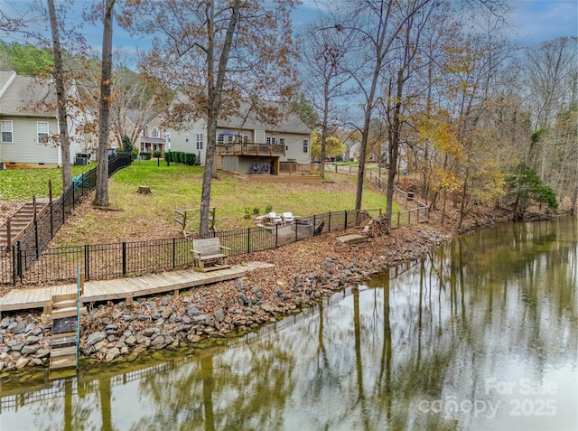 view of dock with a deck with water view and a yard