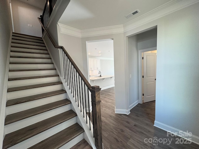 stairway featuring wood-type flooring and ornamental molding