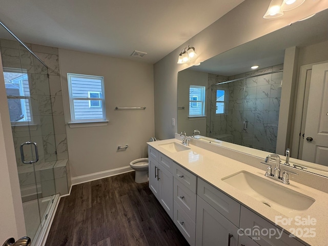 bathroom featuring hardwood / wood-style floors, vanity, toilet, and an enclosed shower