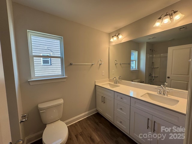 bathroom with hardwood / wood-style flooring, toilet, vanity, and walk in shower