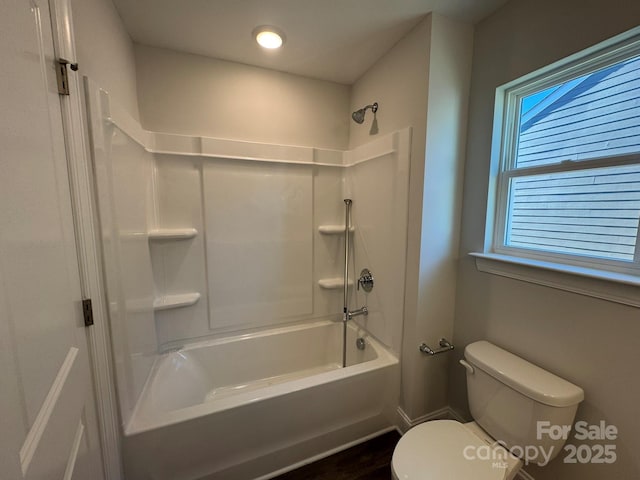 bathroom with shower / tub combination, a healthy amount of sunlight, and toilet