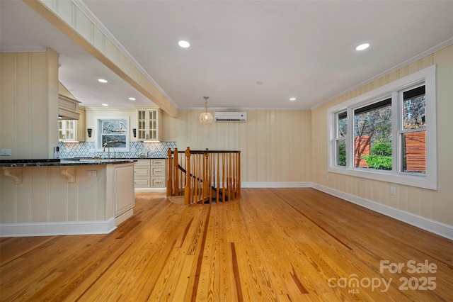 kitchen with a breakfast bar, decorative light fixtures, a wall mounted AC, backsplash, and ornamental molding