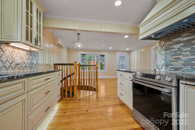 kitchen with electric stove, backsplash, a wall mounted AC, custom exhaust hood, and cream cabinetry