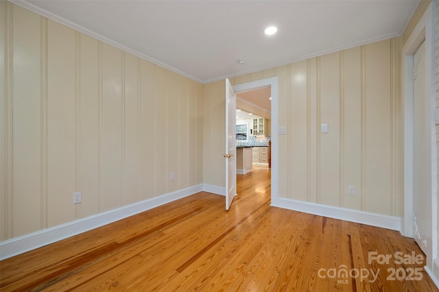 empty room featuring ornamental molding and light hardwood / wood-style floors