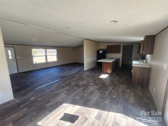 kitchen featuring dark hardwood / wood-style floors, a center island, sink, and a textured ceiling